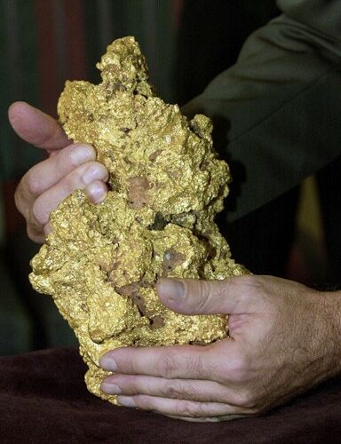 Original caption: PER01:AUSTRALIA-NUGGET:PERTH,AUSTRALIA,9APR00 - What has been described as the world's second largest intact gold nugget is held during its first public display at the Perth Mint in Perth, Western Australia April 9. Based on the latest gold price of $281 an ounce, the 819 ounce lump of almost pure gold contains $230,139 worth of the precious metal. The nugget stands 28cm tall by 18 cm wide, and is estimated to be between 5 million and 70 million years old. Found by an unnamed prospector in the Kalgoorlie Region of Western Australia in 1995, the nugget was hidden under his bed for several years before tried to sell it in the United States. It has since been acquired by Normandy Mining Limited.  pb/Photo by  Annaliese Frank    REUTERS --- Image by © Reuters/CORBIS